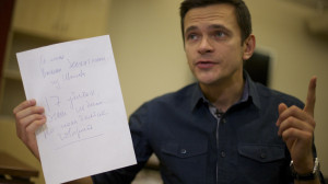 Russian opposition figure Ilya Yashin shows a note he said was written